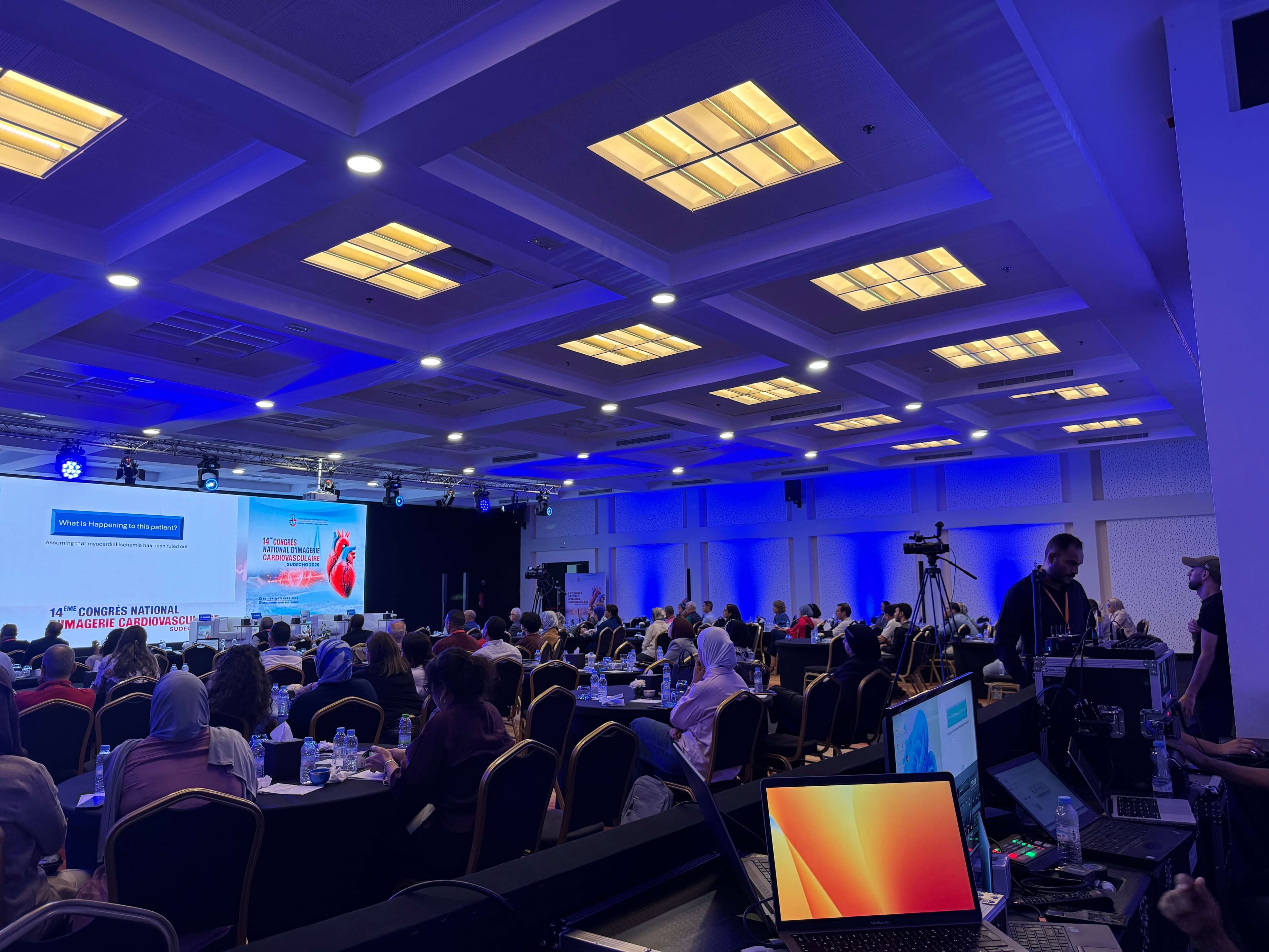 Seminar plenary hall in blue light, with technical control desk and video capture